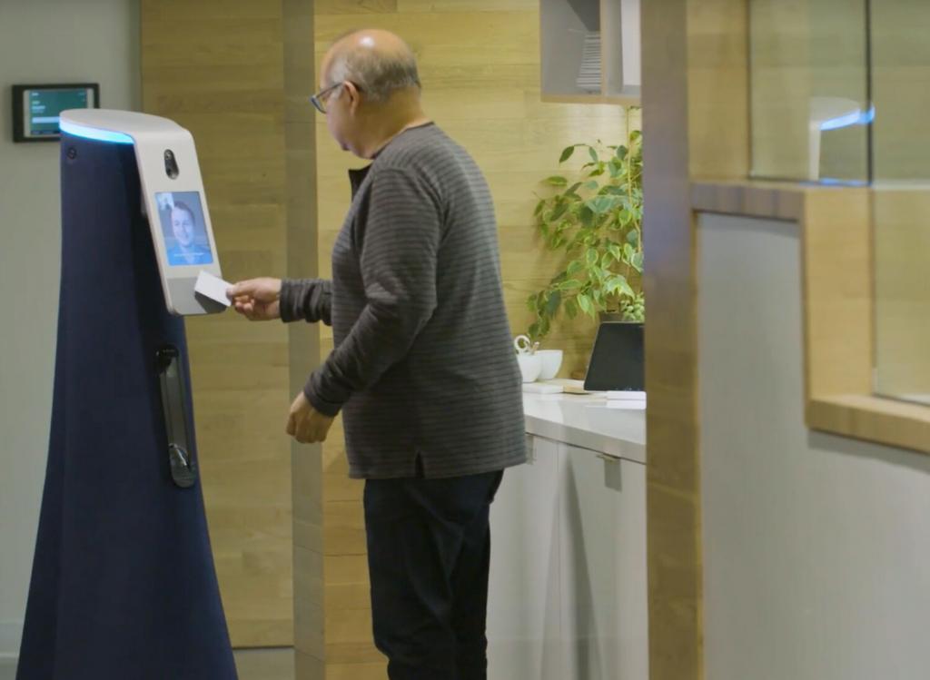 An employee badges in on the Cobalt security robot